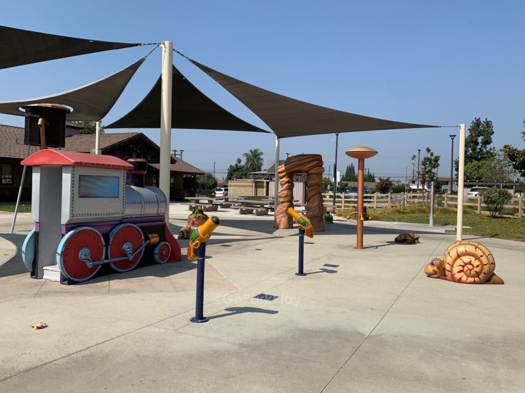 Central Park Playground splash pad with a train slide and snail in Stanton CA
